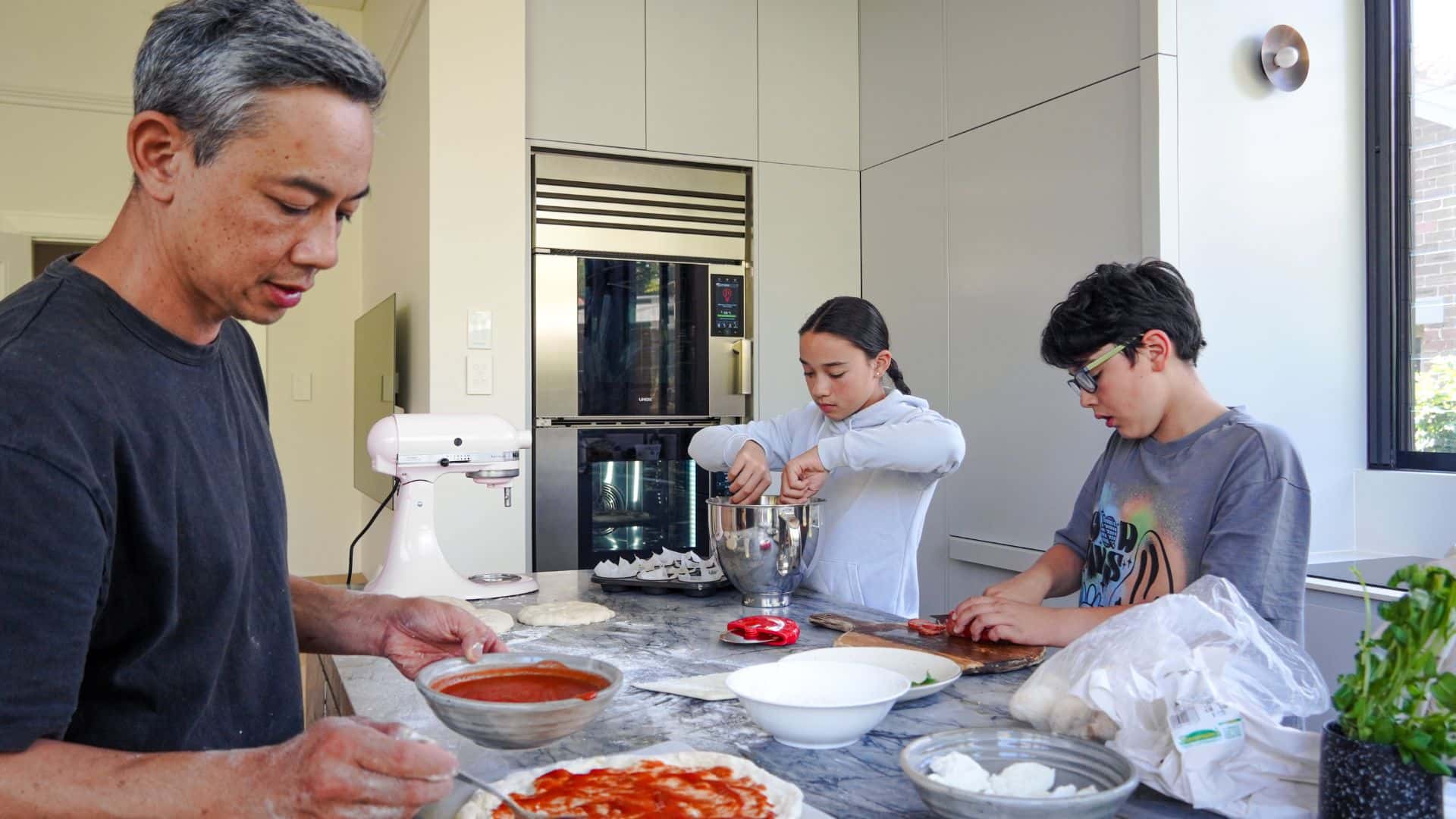 Christopher Thé preparing pizza with his children